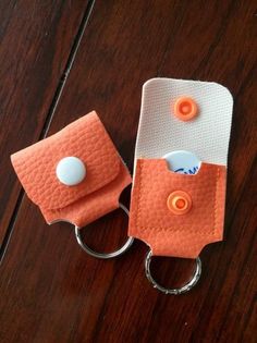 an orange and white cell phone holder on a wooden table next to a pair of scissors