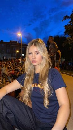 a woman sitting on the ground in front of a crowd