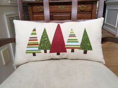 a pillow with trees on it sitting on a chair