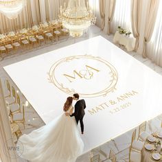 a bride and groom standing on top of a dance floor in front of a chandelier