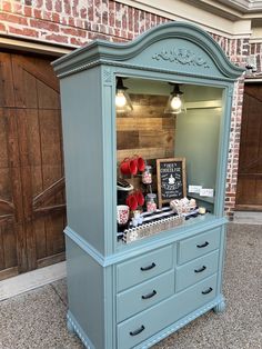 an old dresser is painted blue and has red hearts on it's front door