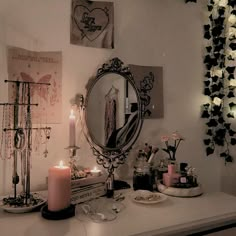 a vanity with candles and jewelry on it