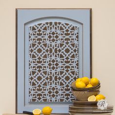 some lemons are sitting in front of a blue door with a decorative screen behind it