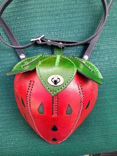 This is a very nice decorative leather Strawberry purse/ bag, all top grain Leather, Hand dyed red and green with black seeds, All handmade and stitched, opens from the top, has a twist closing clasp, Adjustable Strap with buckle 52'' to 56" in length. the purse measures 9 inches from the top to the bottom and 6.5 inches wide. the top has a opening of 4 inches wide x 3 inches and the purse is 7 inches deep tapered down to the point of the Strawberry, perfect for a cell phone, wallet and keys. Green Leather Coin Purse Pouch, Green Leather Coin Purse For Gift, Red Leather Coin Purse With Removable Pouch, Unique Leather Bag As A Gift, Red Leather Pouch Coin Purse, Strawberry Purse, Strawberry Bag, Unusual Handbags, Funky Purses