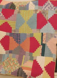 a large colorful patchwork quilt hanging on a wall