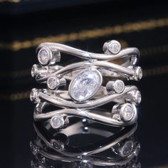 a close up view of a ring with diamonds on the sides and an oval diamond in the middle