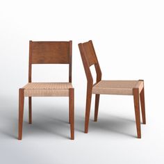 two wooden chairs sitting next to each other on a white surface with one chair facing the other