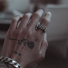 a person's hand with a tattoo on it and a chain around the wrist