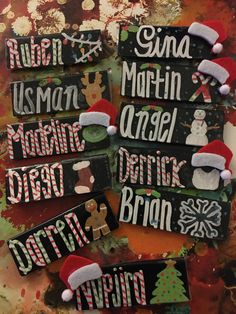 christmas signs with santa hats and snowmen are displayed on a table in front of other holiday decorations