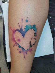 a heart with a stethoscope tattoo on the leg, painted in blue and pink