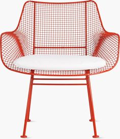 an orange wire chair with a white cushion