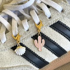 a pair of shoes with charms attached to them on a white and black shoelace