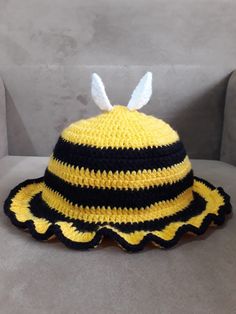 a crocheted bee hat sitting on top of a couch