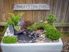 an outdoor pond with rocks and plants in it next to a wooden sign that says fenley's dine - park