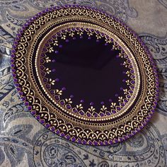 a purple and gold plate sitting on top of a table