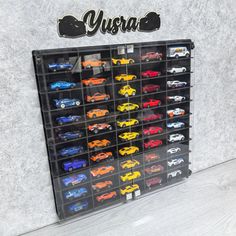 a display case filled with toy cars next to a wall