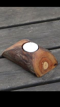 a wooden candle holder sitting on top of a wooden bench