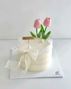 a white cake with pink tulips on top