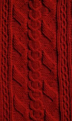 red knitted sweater with cables on it