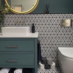 a white sink sitting under a bathroom mirror next to a toilet