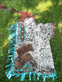 a cowgirl's western outfit laying on the grass with fringes and boots