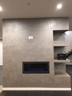 an empty living room with a fireplace and stairs