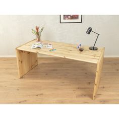 a wooden table sitting on top of a hard wood floor next to a desk lamp