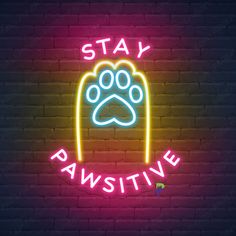 a neon sign that says stay pawstive with a dog's paw on it