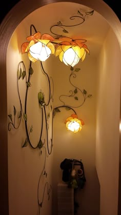 a hallway with some lights on the wall and a light fixture hanging from the ceiling