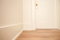 an empty room with white walls and wood flooring is pictured in this image from the front door