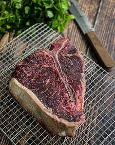 a piece of steak sitting on top of a metal rack