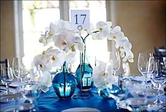 the table is set with blue and white flowers