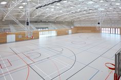 an indoor basketball court with hoops and lights on the ceiling is pictured in this image