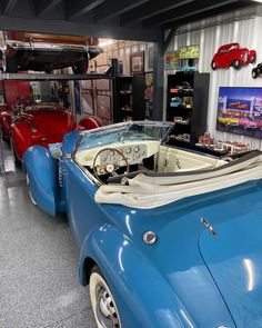 several classic cars are on display in a museum