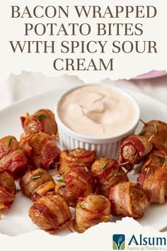 bacon wrapped potato bites with spicy sour cream on a white plate next to a small bowl of dip