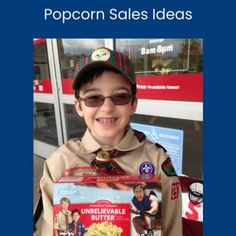 a young boy is holding up a box of popcorn sales ideas for the upcoming movie