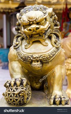 a golden foo foo statue sitting on top of a stone slab in front of gold statues