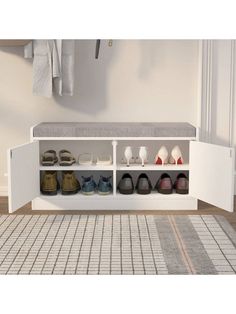 a white shoe rack with shoes on it in the middle of a rug and wall