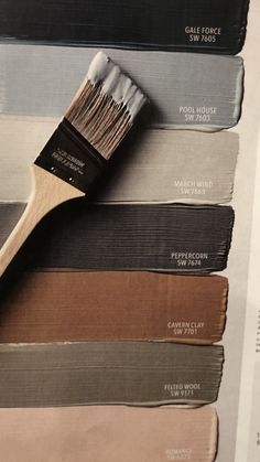 a paint brush sitting on top of some different colors of paint swatches and samples