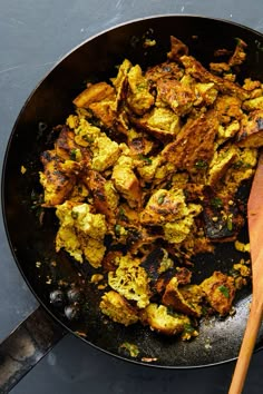 a pan filled with food and a wooden spoon