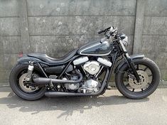 a black motorcycle parked in front of a wall