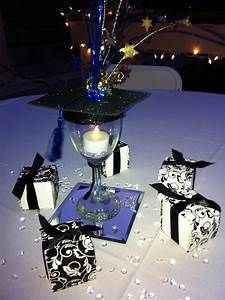 a table topped with boxes and candles on top of a white cloth covered tablecloth