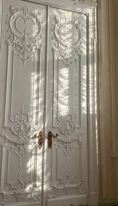 an ornate white door is shown in the sunlight