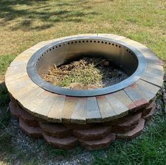 an outdoor fire pit with grass growing out of it