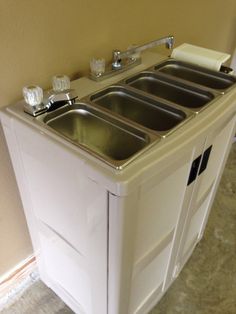 a sink and cabinet in a room with tile flooring on the ground, next to a wall