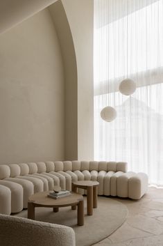 a living room filled with furniture next to a large white curtained window on top of a wall