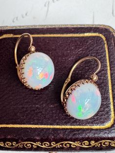 Dating to the late 19th-century France, these delightful dormeuses showcase vibrant opal cabochons with flecks of neon green, bubblegum pink and Sunkist orange, washed by splashes of iridescent yellow, creating a spectacular play-of-color. Hand fabricated in gleaming 18k rose gold, the cabochons are perfectly presented in slender fleur-de-lis prongs, featuring the original back to front closures. These cuties sit snugly beneath your earlobe, making them extremely comfortable to wear. Measurements: 5/8" x 7/16" Opal: 10mm Weight: 2.7 grams Markings: partial French eagles head hallmark for 18 karat gold on the base of the closure Notes: opals are replacements Sleeper Earrings, Bubblegum Pink, Neon Green, 18k Rose Gold, French Antiques, Opal, Jewelry Earrings Dangle, Etsy Earrings, Dangle Drop Earrings