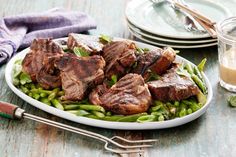 steak and asparagus on a plate with fork, knife and glass of milk