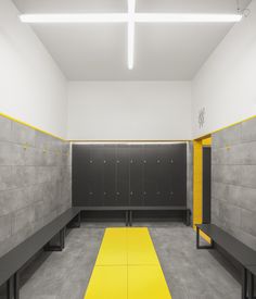 an empty locker room with yellow and black benches