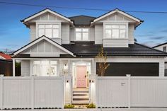 a large white house with a pink door